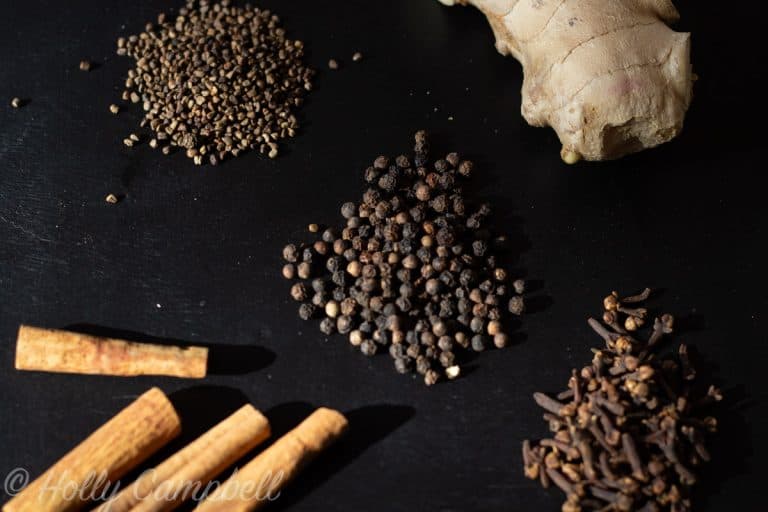 Ingredients for authentic masala concentrate, fresh ginger, cinnamon sticks, cloves, cardamom and black peppercorns