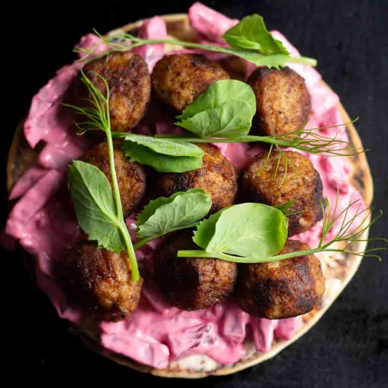 Swedish meatballs served on an open sandwich with Swedish beet and apple salad, garnished with fresh pea shoots